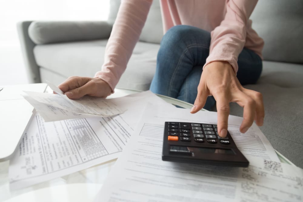 student calculating bills using calculator