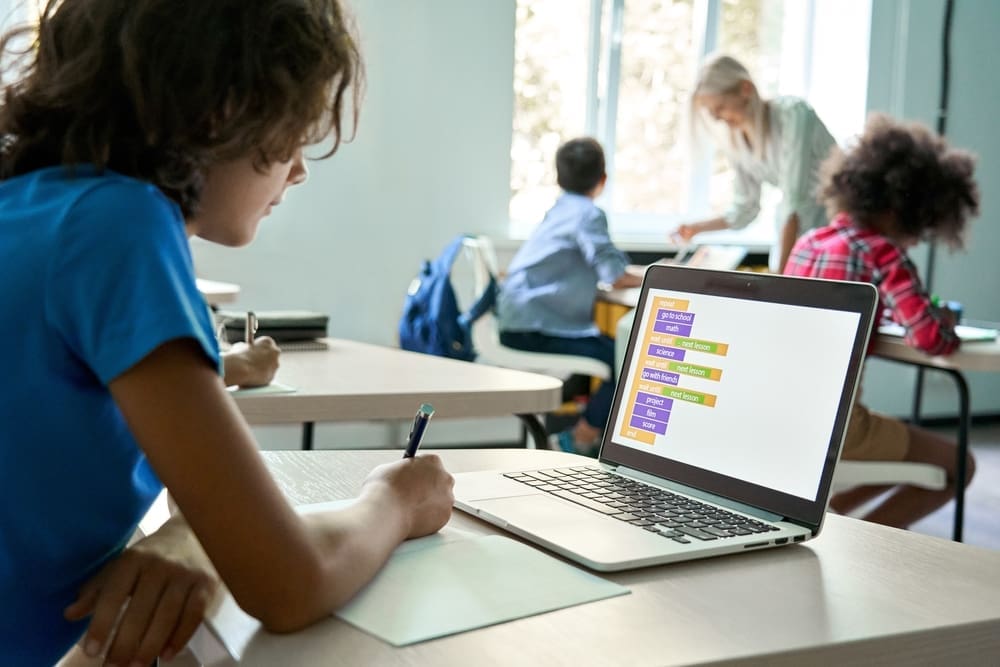 middle school student using laptop in class