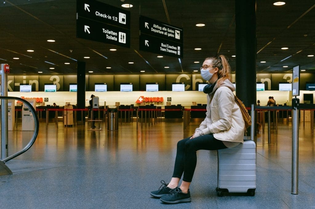 woman sitting on luggage